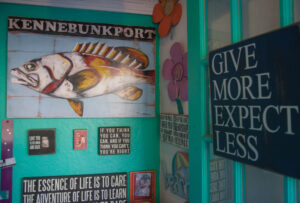 A fish painting and signs decorate the entryway of a shop on Ocean Avenue. kennebunk-jd-fish-paintings