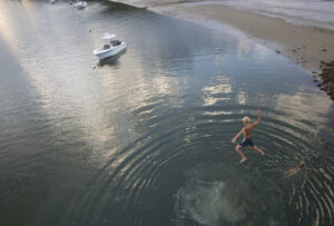 A young boy jumps into the water below from a bridge. york-jd-jump